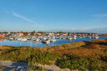 Hou, Denmark - October 06, 2020: View of the yacht harbor of Hou, the sailing boats are attached to the pier and in the background you can see many holiday homes. Taken from a dune.