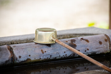 Bamboo and iron made Hishaku at water basin in Shinto Shrine. Hishaku is Japanese traditional ladle to use to scoop out the water for purification. Asian mystic, oriental, religious Shintoism concept