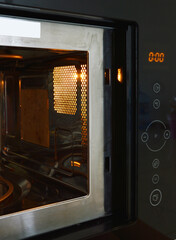Fototapeta premium Microwave oven control panel and lighting inside