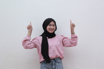 Portrait of confident asian muslim women looked up and pointing to copy space. Beautiful asian woman with casual dress. Beautiful muslim women.