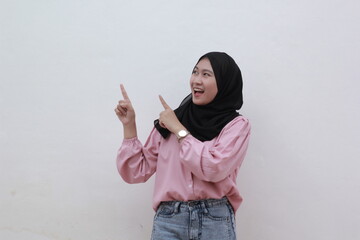 Portrait of expressive young muslim woman find the inspiration and pointing to copy space. Beautiful asian woman with casual dress. Beautiful muslim women.