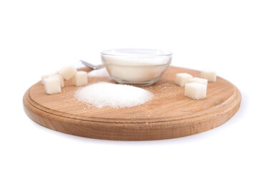 Fototapeta na wymiar Sugar in a glass bowl, sugar cubes and gloss on a wooden board against a white
