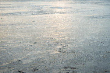 Frozen blue lake with sunset rays