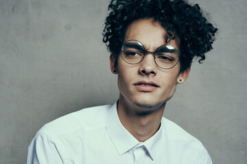 happy guy with curly hair and glasses teen model photo studio emotions Copy Space