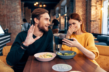 cute men and women in a restaurant with a phone in their hands selfie