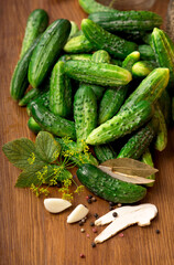 Food background. Organic products, healthy food, harvesting for future use, pickling vegetables, pickling cucumbers. Cucumbers with garlic, salt, dill and empty glass jar for pickling.