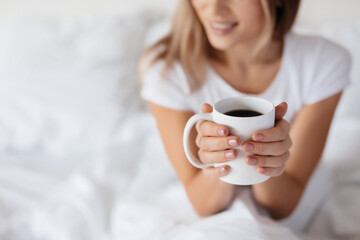 Joyous lady savouring her morning cup of coffee