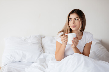 Attractive young lady starting her day with cup of coffee