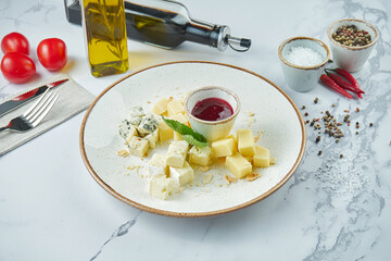Assorted mouth-watering cheeses: dorblu, parmesan, soft cheeses, served in a white plate with grapes and honey. cheese plate