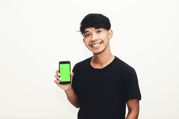 Asian man wearing casual black t-shirt pointing at green screen cellphone