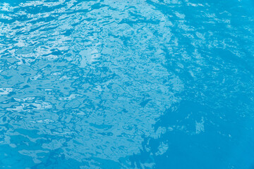 Fototapeta na wymiar Blurred image of the blue water surface wave in the swimming pool.
