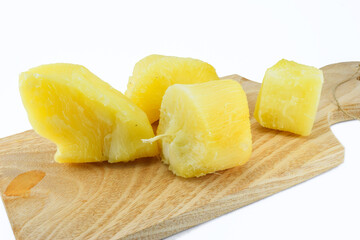 steamed cassava on a wooden cutting board