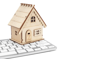 Model of house with computer keyboard on white background.