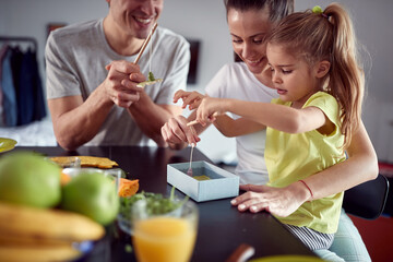 A young couple and their daughter playing a fishing game after a breakfast at home. Family, breakfast, together, home