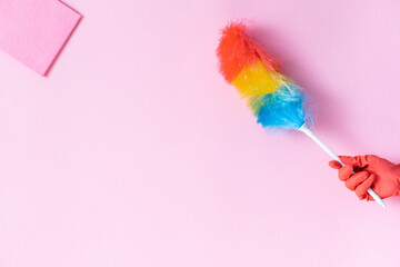 hand with a brush on a pink background, cleaning
