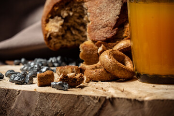 Bread, drying and a glass of pumpkin juice on a wooden stump with a beige background