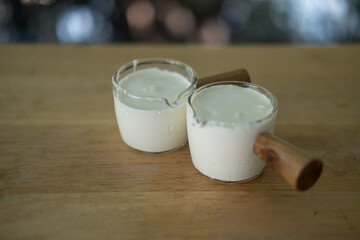 Freshly whipped cream in small glass cup ingredient for food or beverage
