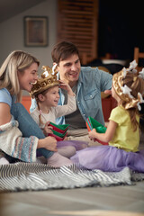 Young happy family sitting on the floor and playing at home together. Family, playing, home,...