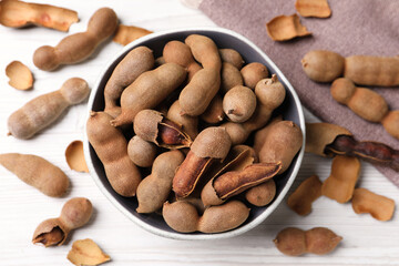 Delicious ripe tamarinds on white wooden table, flat lay. Exotic fruit