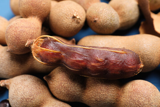 Delicious ripe tamarinds on blue background, closeup