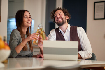 A young handsome business couple toasting at home after successful working day. Business, relationship, leisure