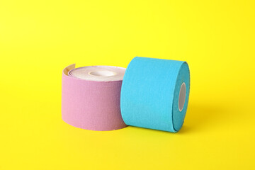 Bright kinesio tape in rolls on yellow background