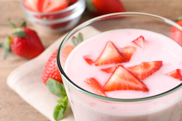 Delicious drink with strawberries in glass on table, closeup
