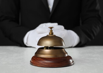 Butler at white desk with service bell, closeup view