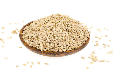 Hullled sunflower seeds pile in bowl on white background.