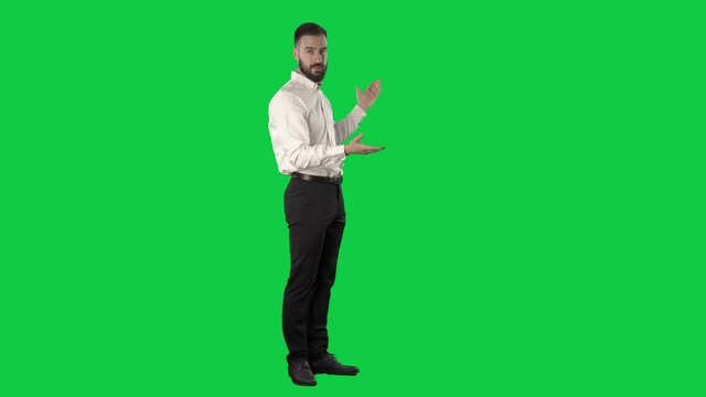 Confident announcer or presenter business man talking and showing empty copy space. Full length on green screen chroma key background.