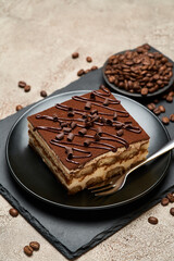 Portion of Traditional Italian Tiramisu dessert on grey concrete background