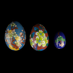 set of wooden Easter eggs with floral patterns on isolated black background