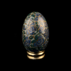 wooden Easter egg with floral patterns on isolated black background