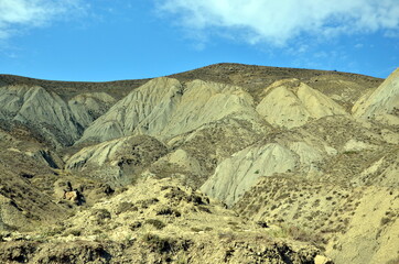 Landscape with grey mountains , blue sky and clouds