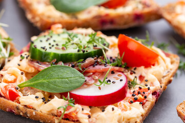 Sandwiches with cream cheese, vegetables and salami.