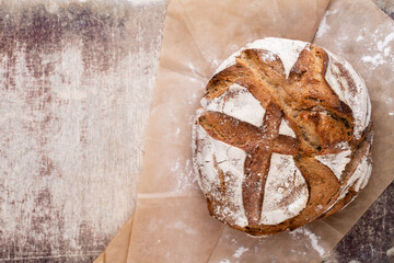 Gold rustic crusty loaves of bread and buns on wooden background. Still life captured from above top view, flat lay.