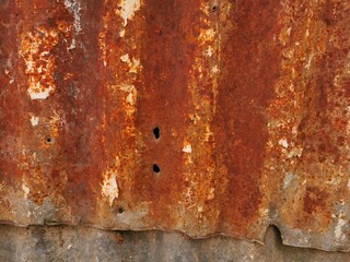 closeup of weathered textured overlapping rusty and corroded metal sheets with holes
