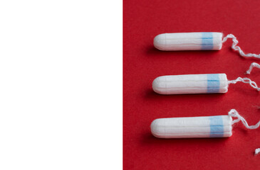 cotton tampon for women period days with selective focus on red background. Hygiene products for women's monthly menstruation. White protection tampons for female health care. Copy space. 