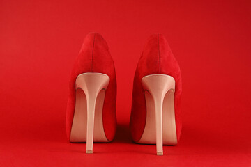 beige high heels red shoes close up on red background