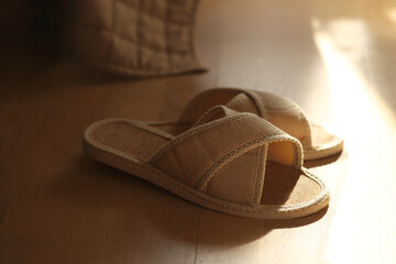 home beige cozy slippers on the floor near the bed