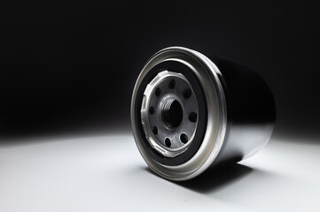 New black engine oil filter for auto on a gradient black and white background