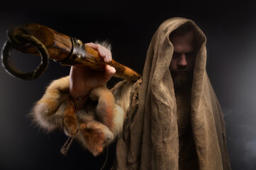 Portrait of a medieval bearded military monk, dressed in animal skins and burlap, holding a battle ax. Low key. Focus on your clothes. Atmospheric portrait of a character from a RPG game