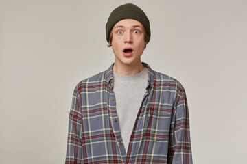 Shocked looking male, disturbed guy with blond hair. Wearing checkered shirt and beanie. People and...