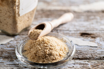 nutritional yeast in flakes, deactivated, not live, B vitamins, wood background, close-up, side view