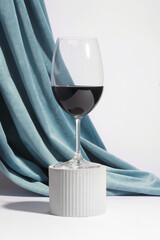 Wine glass on a concrete podium over a white background