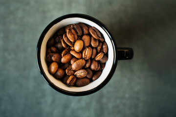 Grains de café dans une tasse noire et blanche