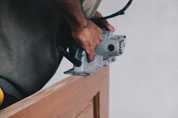 Wood working of teak wood door inside modern new house.