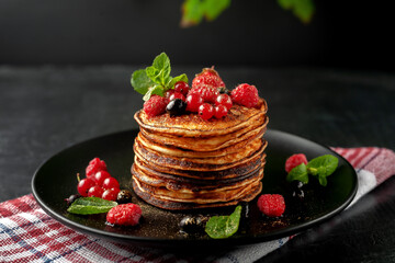 Delicious, only baked pancakes with fresh fruits of raspberries, currants and strawberries