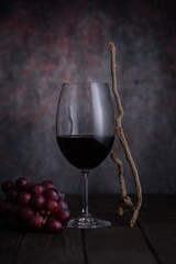 Wine glass and grapes on a dark background