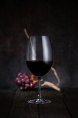 Wine glass and grapes on a dark background